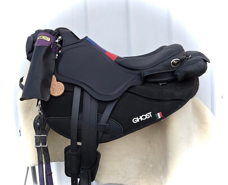 Vista laterale di una sella Ghost mod. Endurance in pelle nera con dettagli tricolore sul seggio, completa di porta borraccia, marsupio e sottosella sagomato nero con logo Ghost.