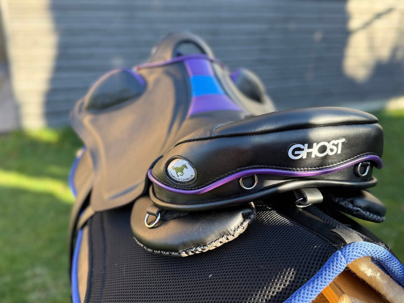 Vista posteriore della paletta di una sella Ghost E in pelle nera, con bordatura viola, anelli per accessori e logo Ghost ben visibile.
