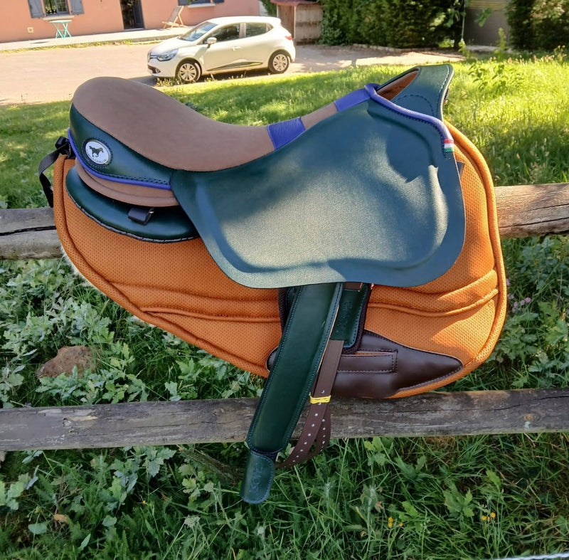 Vista profilo di una sella Ghost verde e marrone con dettagli blu, appoggiata su un sottosella arancione.